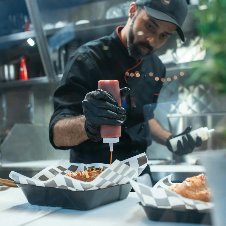 Gloved hands preparing food in a professional kitchen